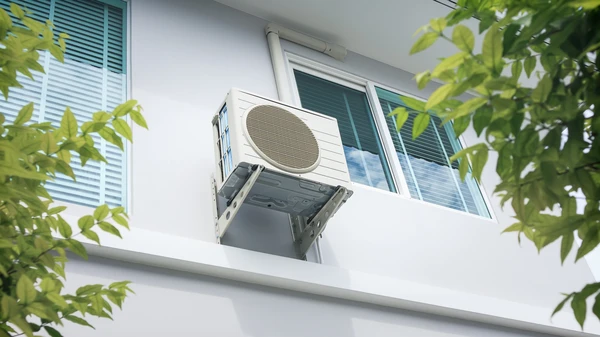 Extérieur d'un bâtiment résidentiel moderne avec unité de climatisation split montée sur façade blanche