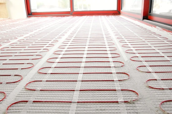 Chantier de construction intérieur avec système de chauffage au sol en cours d'installation